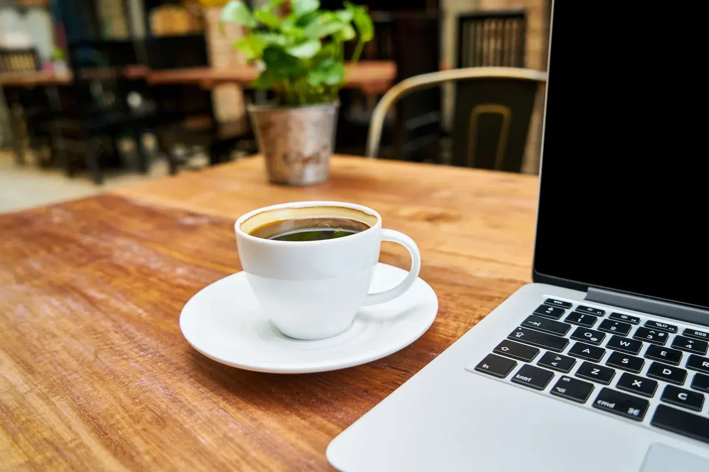 Właściciel restauracji przegląda trendy technologiczne na laptopie przy kawie