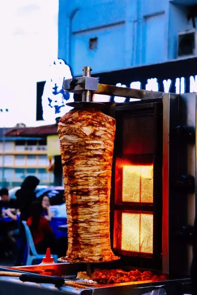 Carn de kebab acabada de tallar a punt per servir en un local de kebab ple