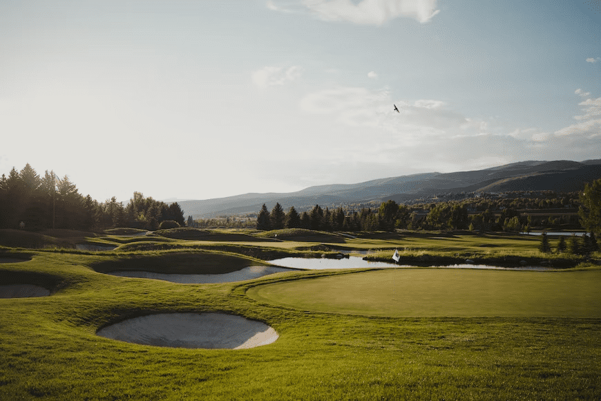 Golf course with mountains in the background.