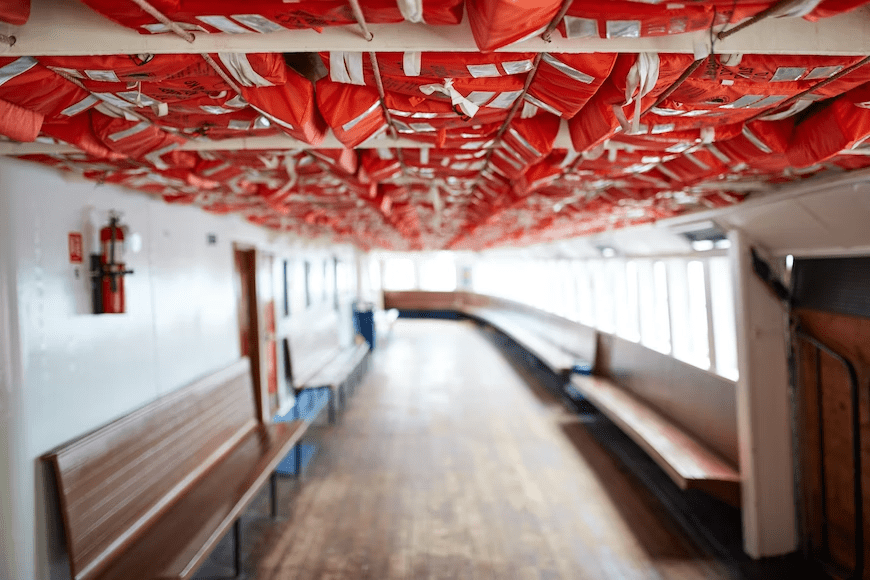 Lifejackets hanging from the ceiling inside of a boat.
